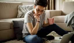 woman sitting on the floor reading and thinking