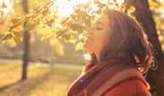 Mujer al aire libre sonriendo con los ojos cerrados