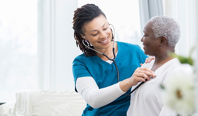 Nurse checking patient's heart beat