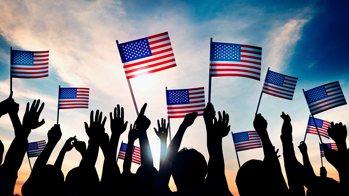 People holding American flags up into the air.