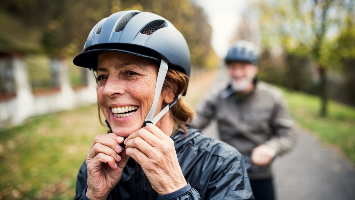 Older adult couple wearing bike helmets