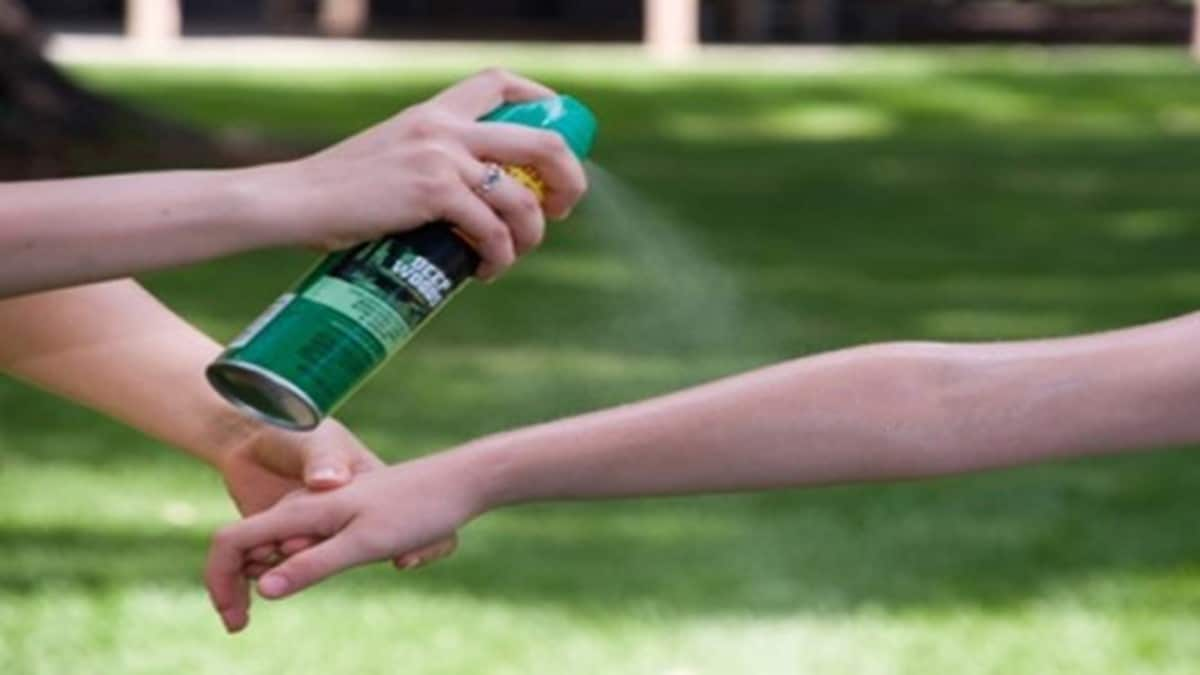 insect repellent being sprayed on a person's arm