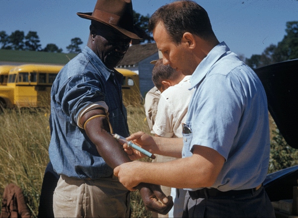 Image of doctor administering shot to patient.