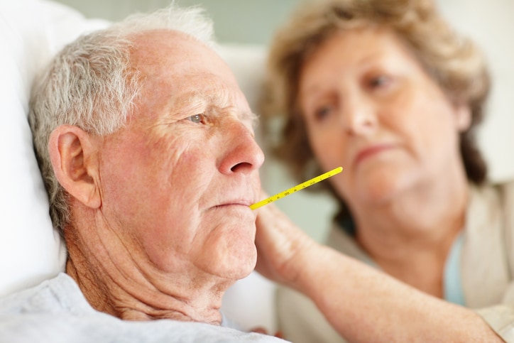 Worried senior woman comforting a sick elderly man