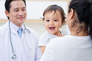 Male doctor with mother and smiling baby