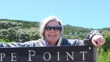 Woman standing behind a sign outdoors