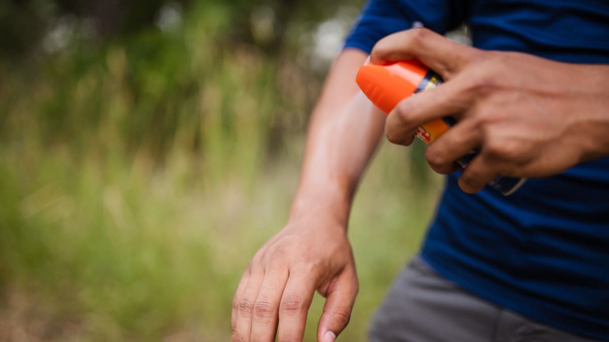 Person applying insect repellent to their arm