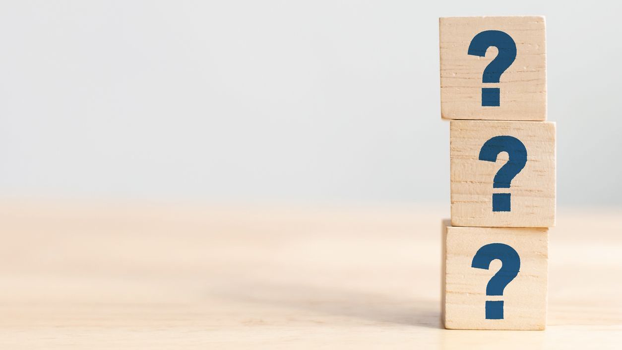 Three stacked wooden blocks with question marks.