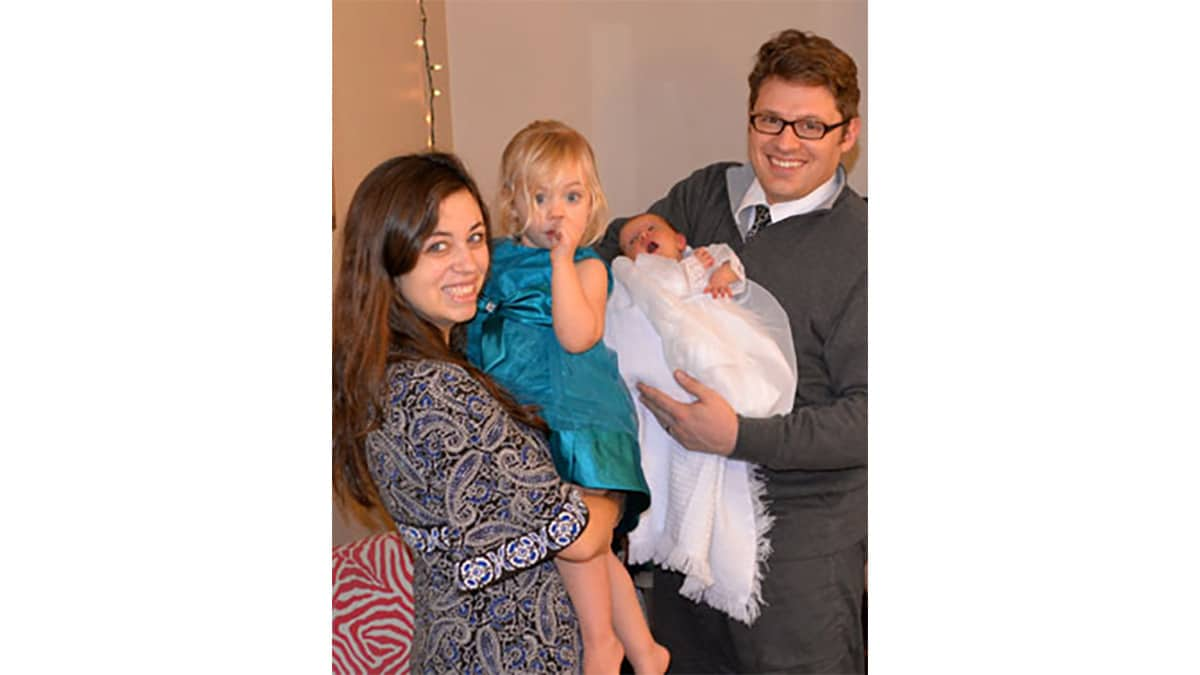 Olive's mother holding a toddler girl and her father holding baby Olive