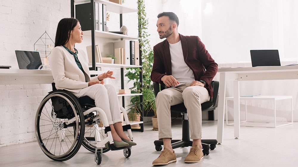 woman in wheelchair in a discussion with co-worker