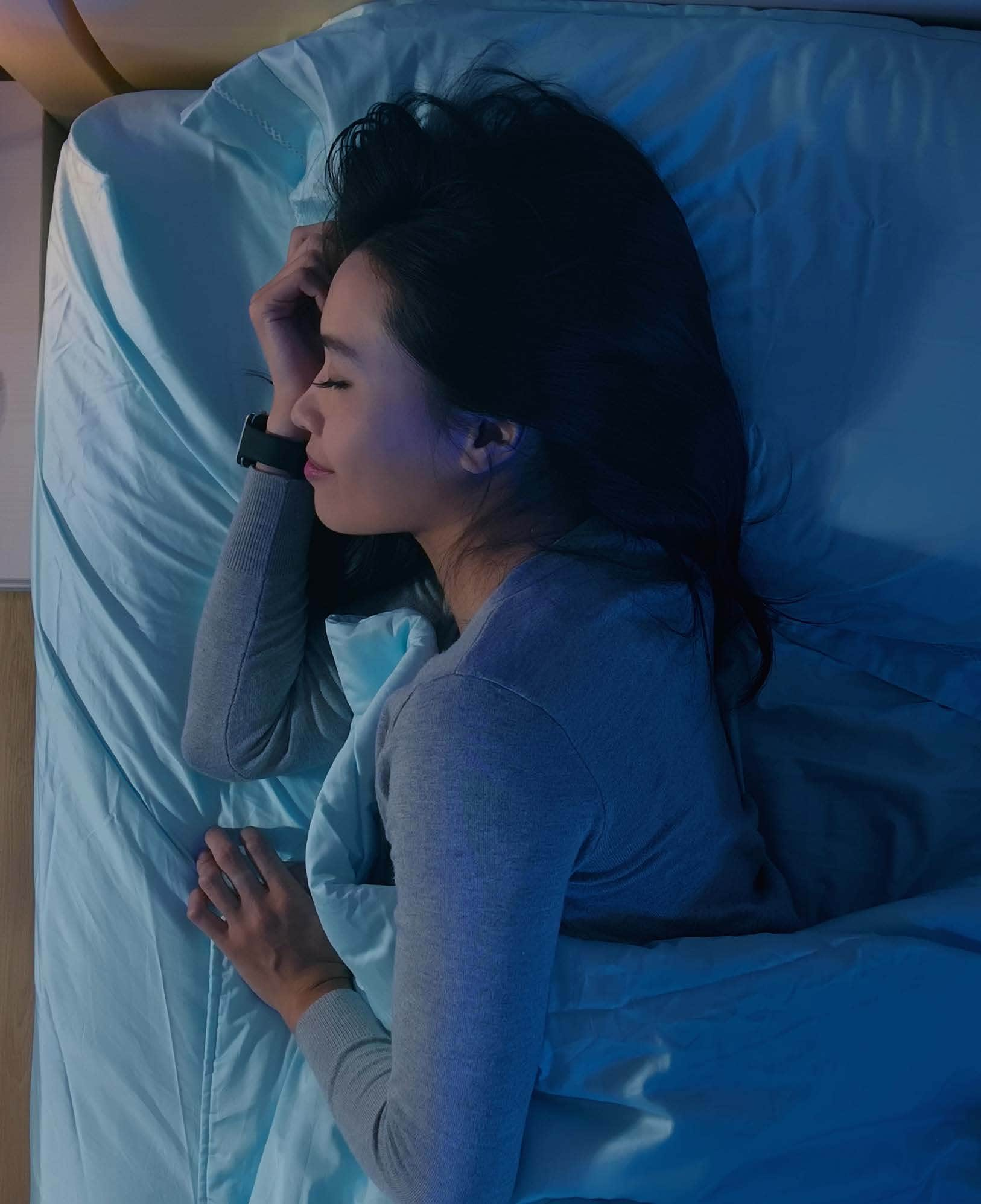 A woman gets a good night's rest in a dimly lit room. Photo credit: iStock/RyanKing999