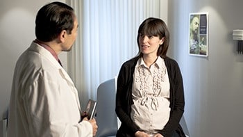 Una mujer embarazada hablando con el médico.